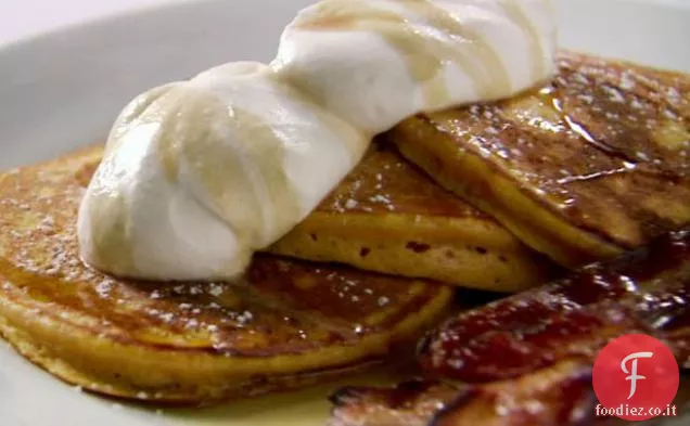 Frittelle di zucca arancione con panna montata alla vaniglia, sciroppo d'acero alla cannella e pancetta tagliata spessa