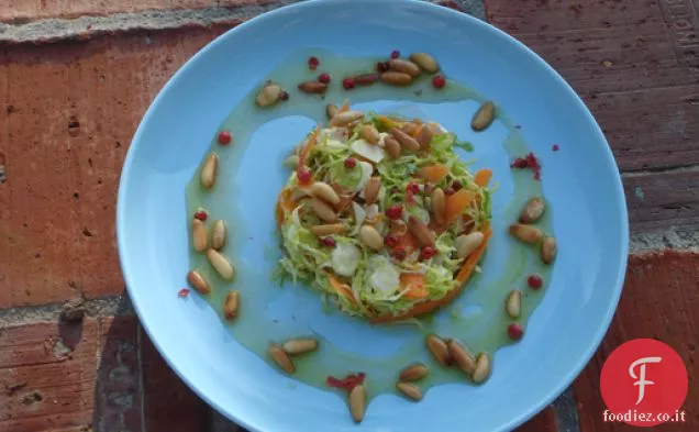 Insalata di cavoletti di Bruxelles crudi tagliuzzati con grani di pepe rosso e Ho