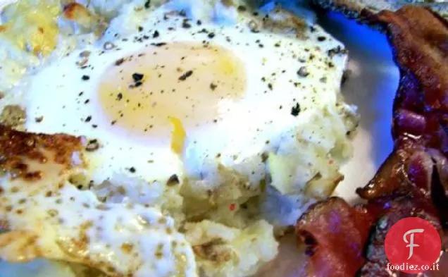 Uova al forno su un letto di patate con pancetta