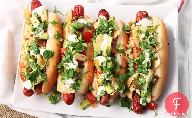 Hot dog avvolti in pancetta con avocado, pomodoro, cipolla, maionese e patatine