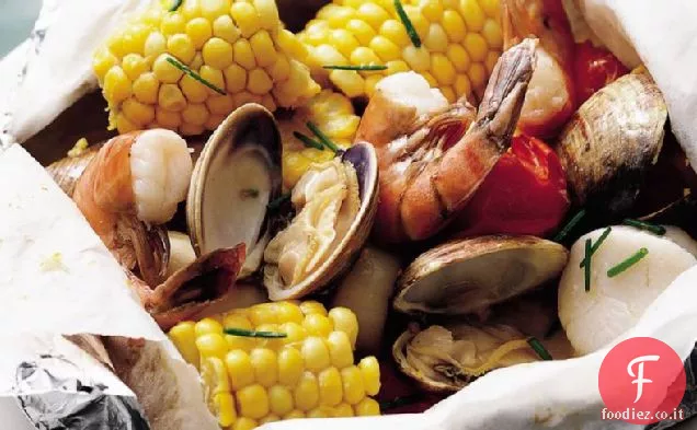 Confezioni di fogli di pesce alla griglia con burro di limone ed erba cipollina
