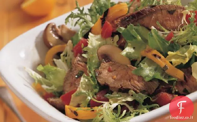 Insalata di bistecca gettata con condimento piccante all'aglio