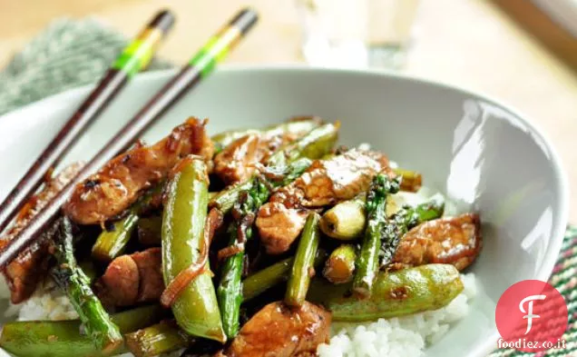 Carne di maiale saltata in padella con asparagi e piselli a scatto di zucchero