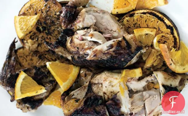 Pollo agli agrumi alla griglia sotto un mattone