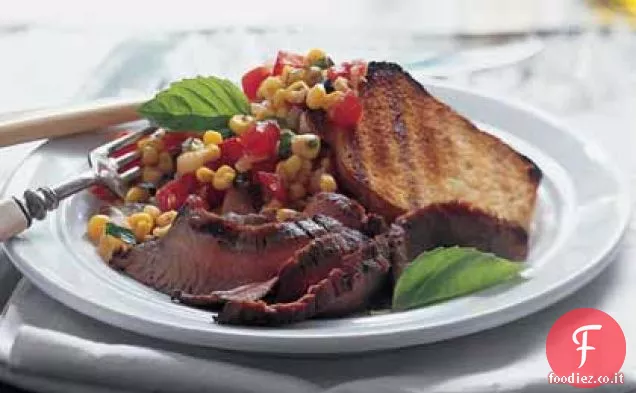 Bistecca al fianco con salsa di mais e pomodoro e pane all'aglio alla griglia
