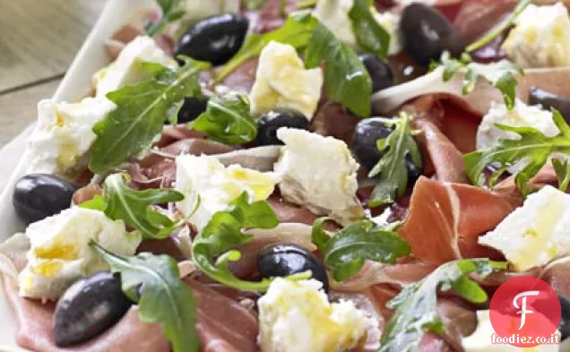 Piatto di prosciutto serrano, olive, feta e rucola con crostini fatti in casa