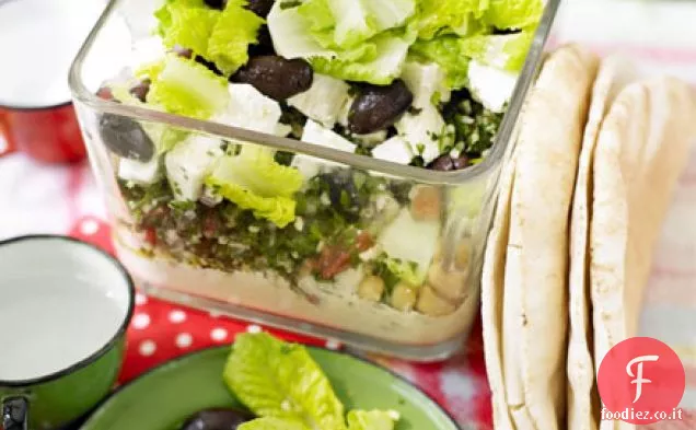 Ciotola da picnic a strati di hummus, tabbouleh e feta
