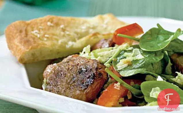 Insalata di spinaci con carne di maiale speziata e condimento allo zenzero