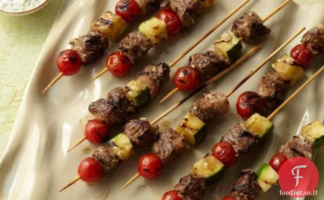 Spiedini di agnello alla griglia con pomodori, zucchine e salsa allo yogurt