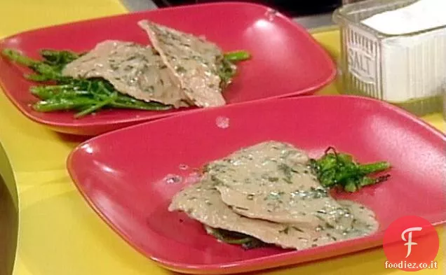 Carne di vitello saltata con limone su un letto di broccoli Rabe