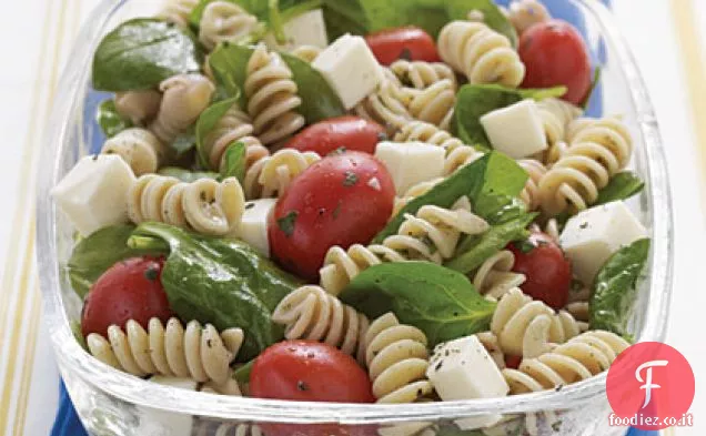 Insalata di pasta con spinaci, pomodoro e mozzarella fresca con condimento italiano