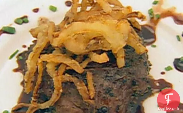 Filetto di manzo incrostato di pepe su pomodoro di manzo con formaggio di capra, cipolle fritte francesi e salsa di aceto balsamico