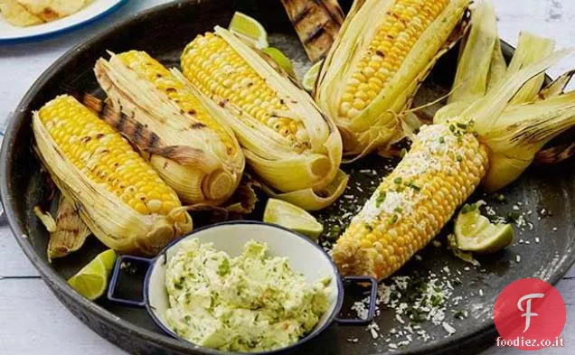 Grigliata di mais sulla pannocchia con burro all'aglio, lime fresco e formaggio Cotija