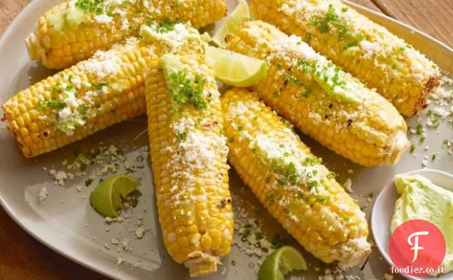 Grigliata di mais sulla pannocchia con burro all'aglio, lime fresco e formaggio Cotija