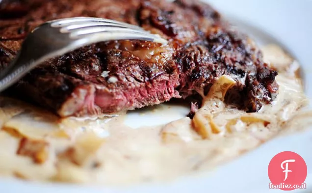 Bistecca di ribeye alla griglia con salsa di formaggio blu di cipolla