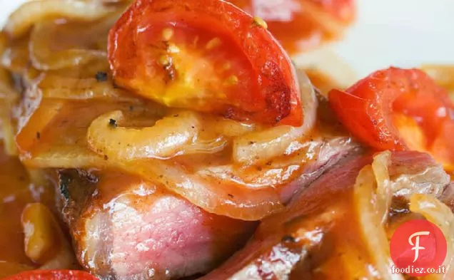 Bistecca scottata in padella con salsa di pomodoro e cipolla in agrodolce