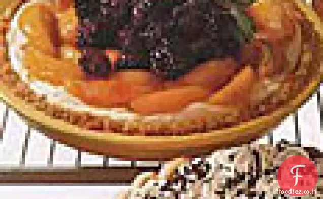 Torta di crema di formaggio condita con pesche e more