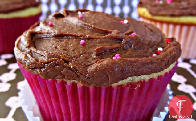 Cupcakes gialli pieni di marmellata con glassa fondente