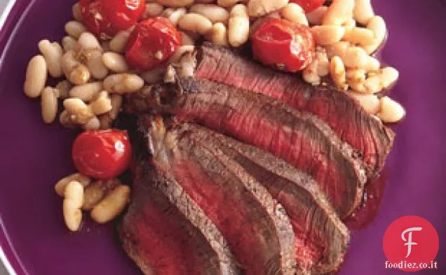 Bistecca strofinata con spezie con fagioli bianchi e pomodorini