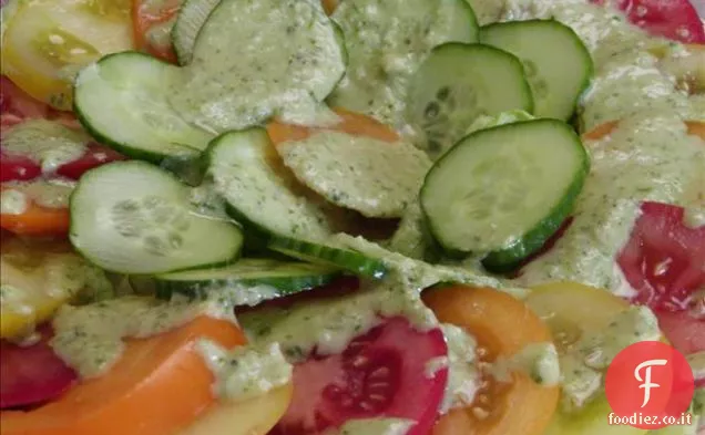 Insalata di pomodori e cetrioli con un condimento simile al pesto.