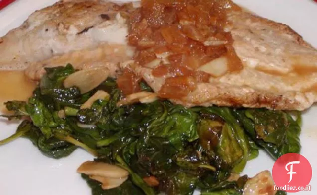 Tilapia in padella con basilico al lime Beurre Blanc su un letto di appassimento