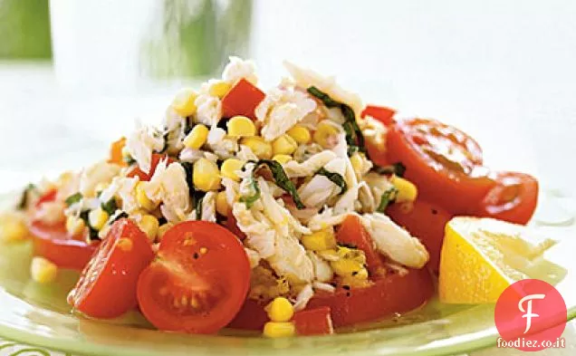 Insalata di granchio, mais e pomodoro con condimento al limone e basilico